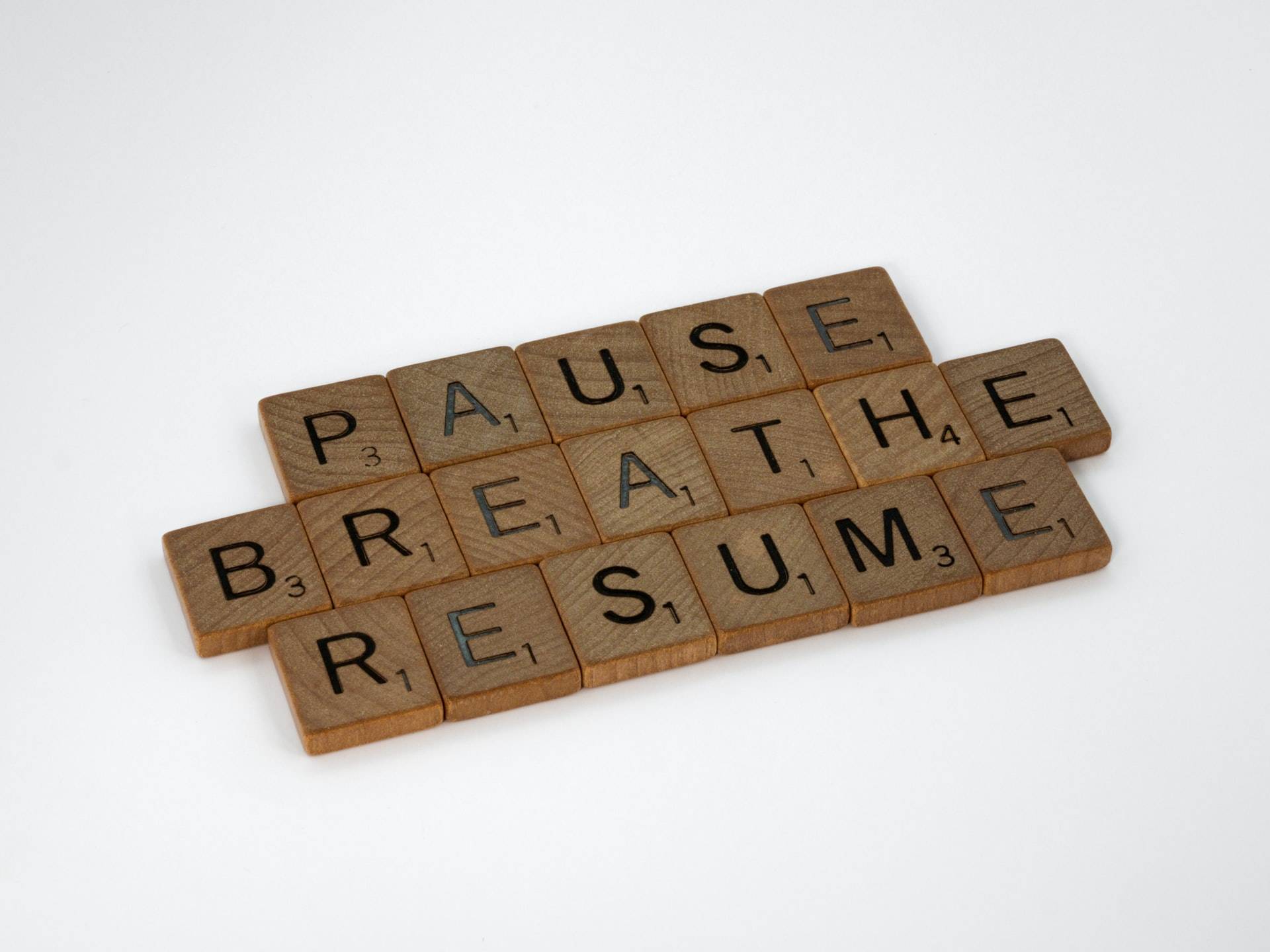 the words pause, breathe, resume written with scrabble letters