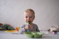 Baby putting a decoration on a birthday cake.