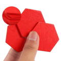 A hand holding red wooden puzzles. 