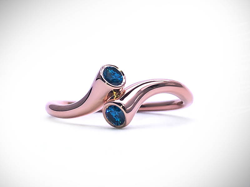 Pink gold twist ring with two blue diamonds