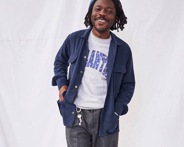 Man smiling wearing navy blue overshirt made from recycled cotton and organic cotton from UK men's sustainable clothing brand Neem