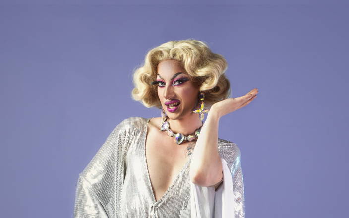Drag queen in silver gown posing with her arm raised (preview)