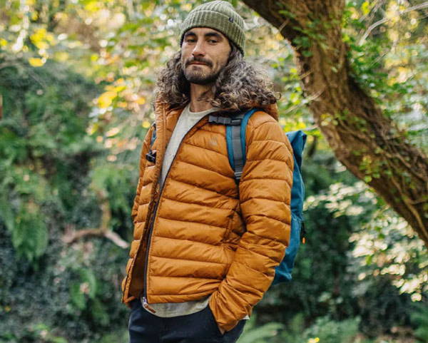 Man wearing orange recycled polyester insulated jacket from UK based sustainable men's clothing brand Passenger clothing