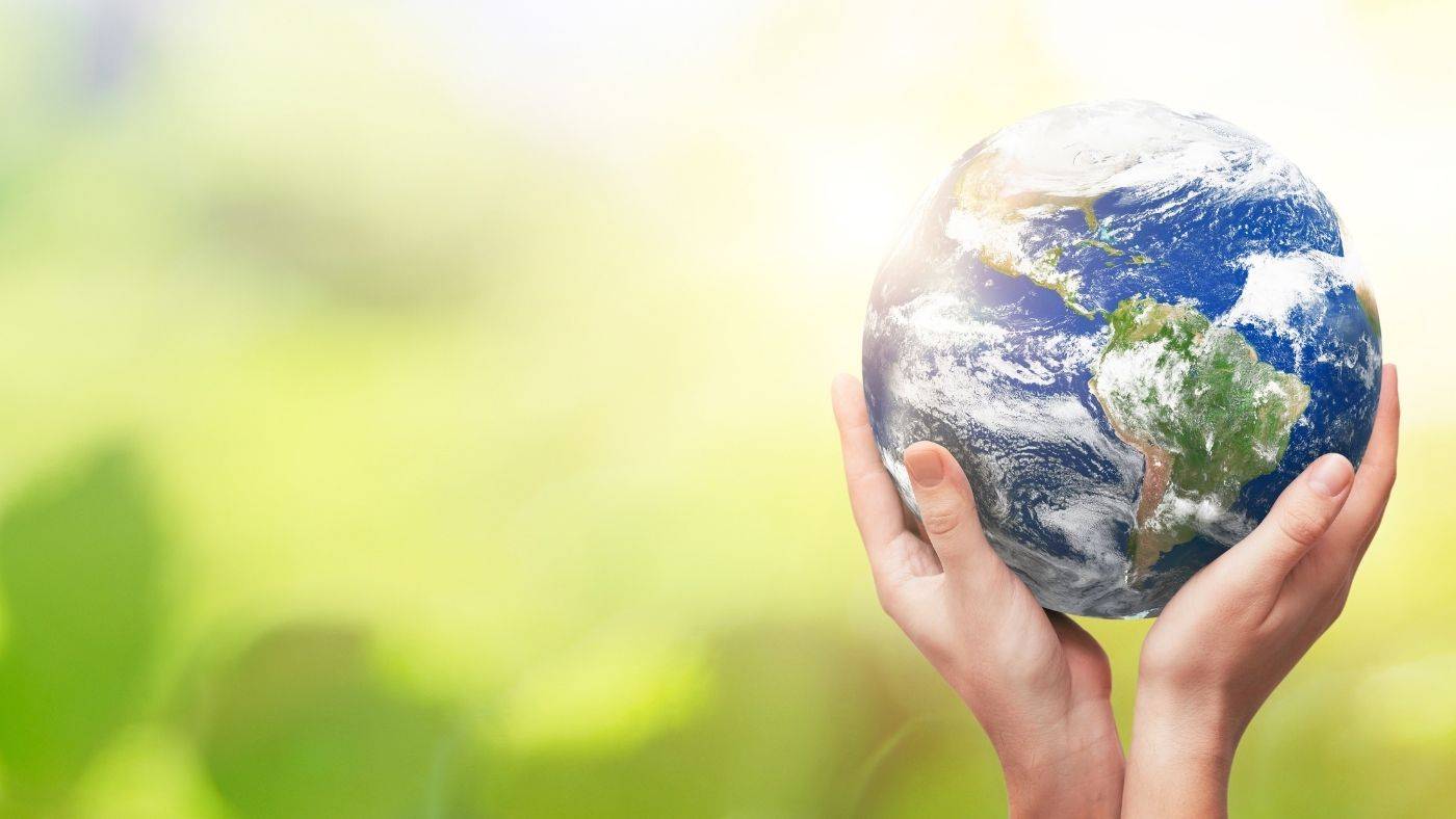 Earth in Women's Hands set amongst green background Earth Day