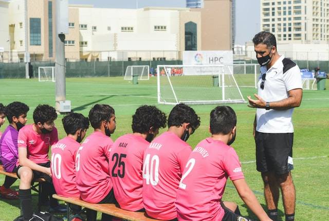 a soccer coach teaching a young team