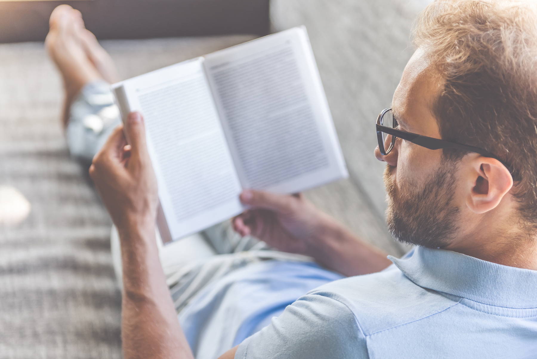 Man following tips to improve mood by relaxing with a book