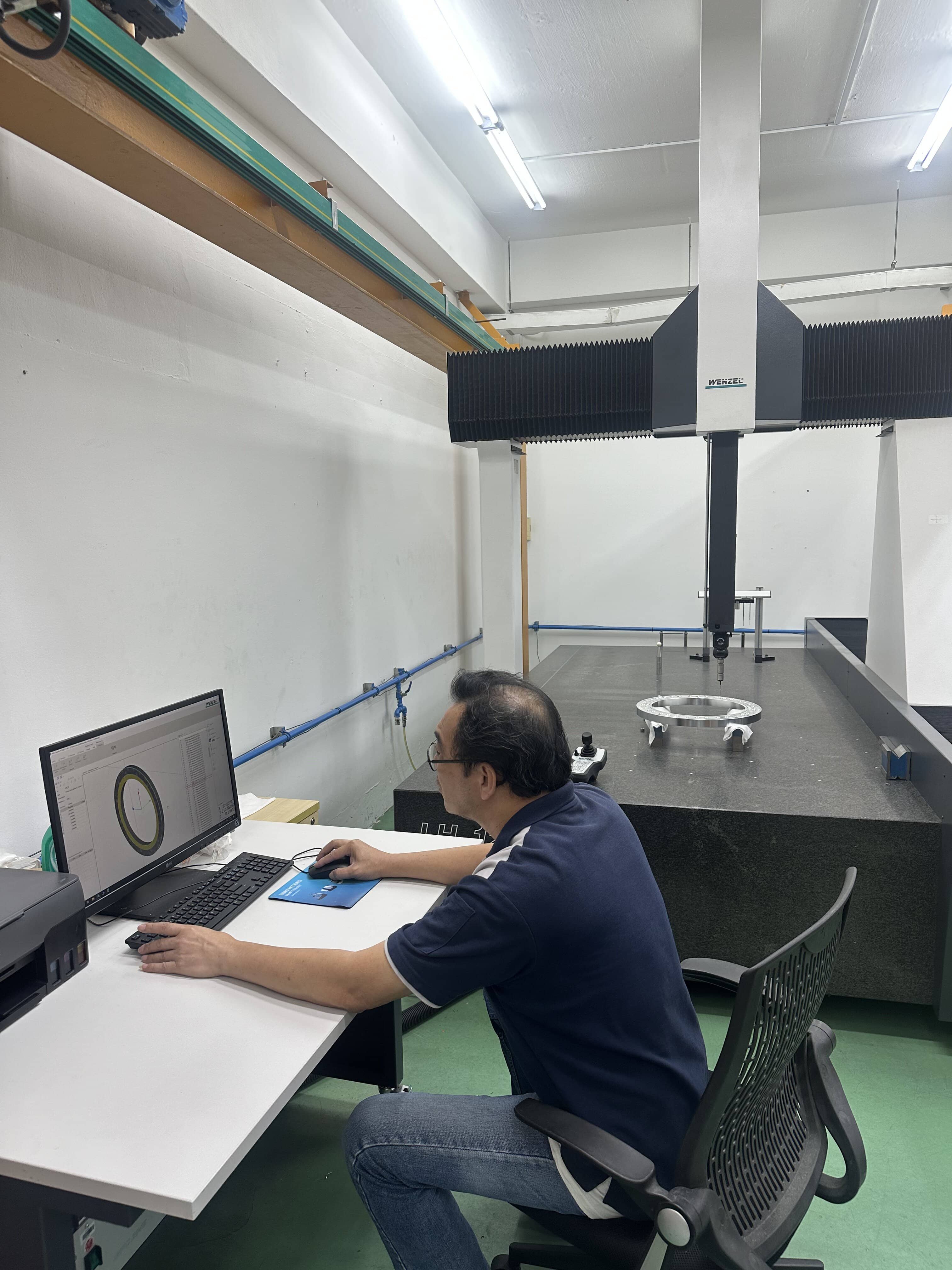 QC operator using a CMM machine to inspect a part