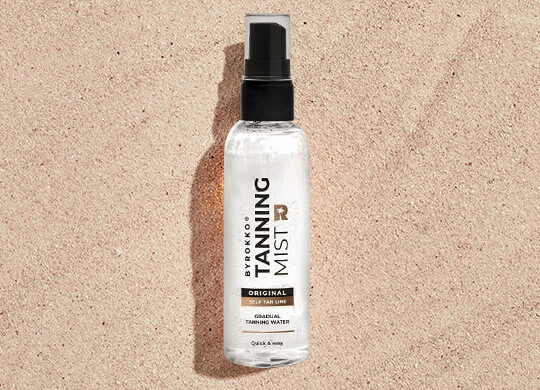 ByRokko Tanning Mist lying on sand.