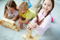 Children playing with wooden Montessori blocks.