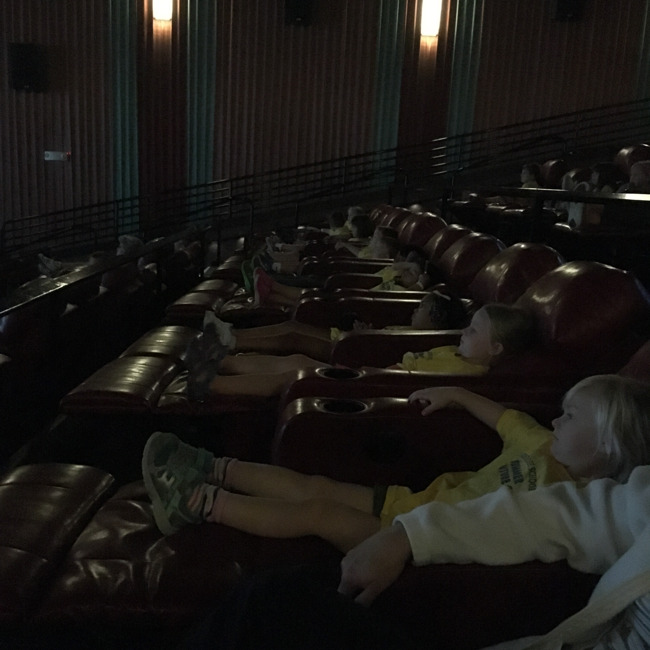Primrose students relax on large lounge seats as they watch a movie for film week