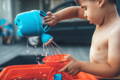 Baby putting a decoration on a birthday cake.