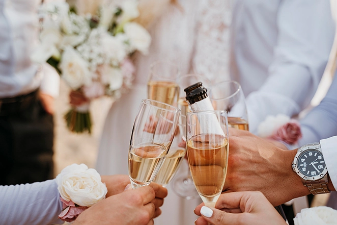 Photo des gens prenant un verre lors d'un mariage sur la plage.