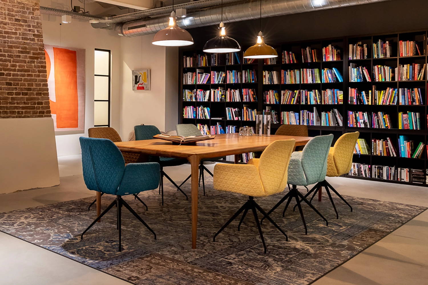 Three Large Coolicon lamps lighting a table in a room with tall bookshelves filled with books