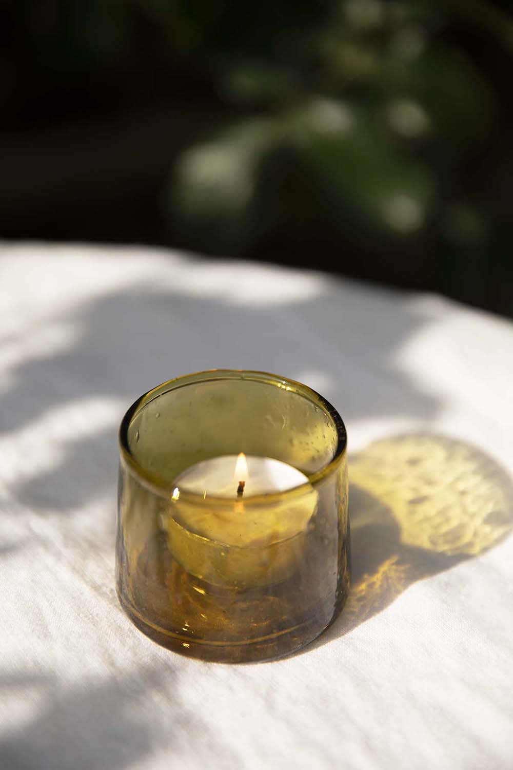 The Moroccan Glass Tea Light Holder in bronze is ethically made from 100% handblown recycled glass for Socco Designs.