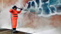 removing graffiti with pressure washer