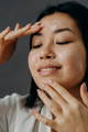 Woman putting on a face peeling for dewy skin