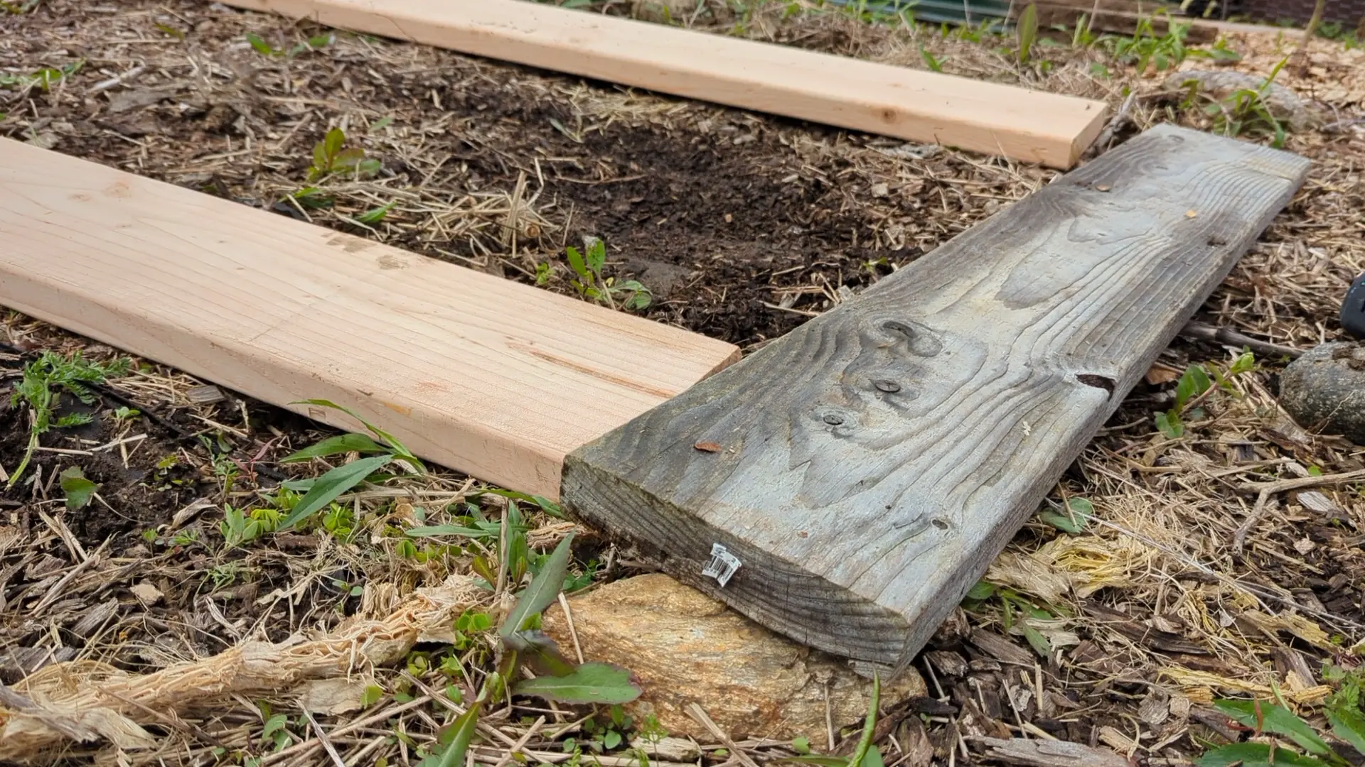 Three pine boards laying on the ground.