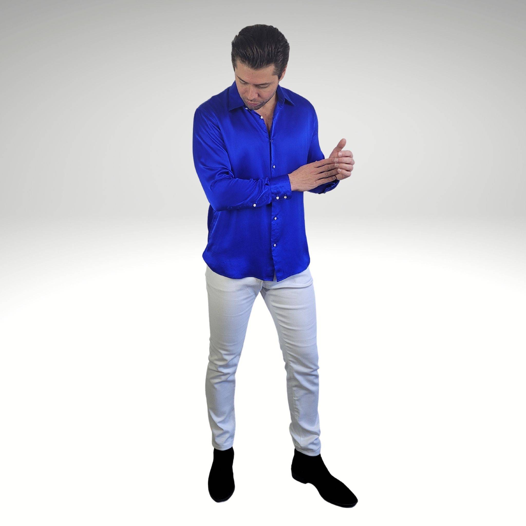 photo of a model wearing a blue silk dress shirt with white skinny jeans and black chelsea boots