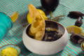 Pelle d’Oca seppie al nero posate su crema di topinambur con cialda croccante di polenta