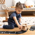 Little boy playing with wooden toys in his playroom.