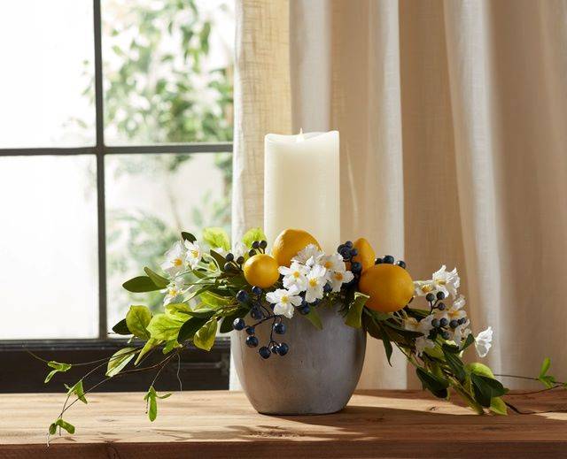 cement container with pillar candle and lemon floral greenery