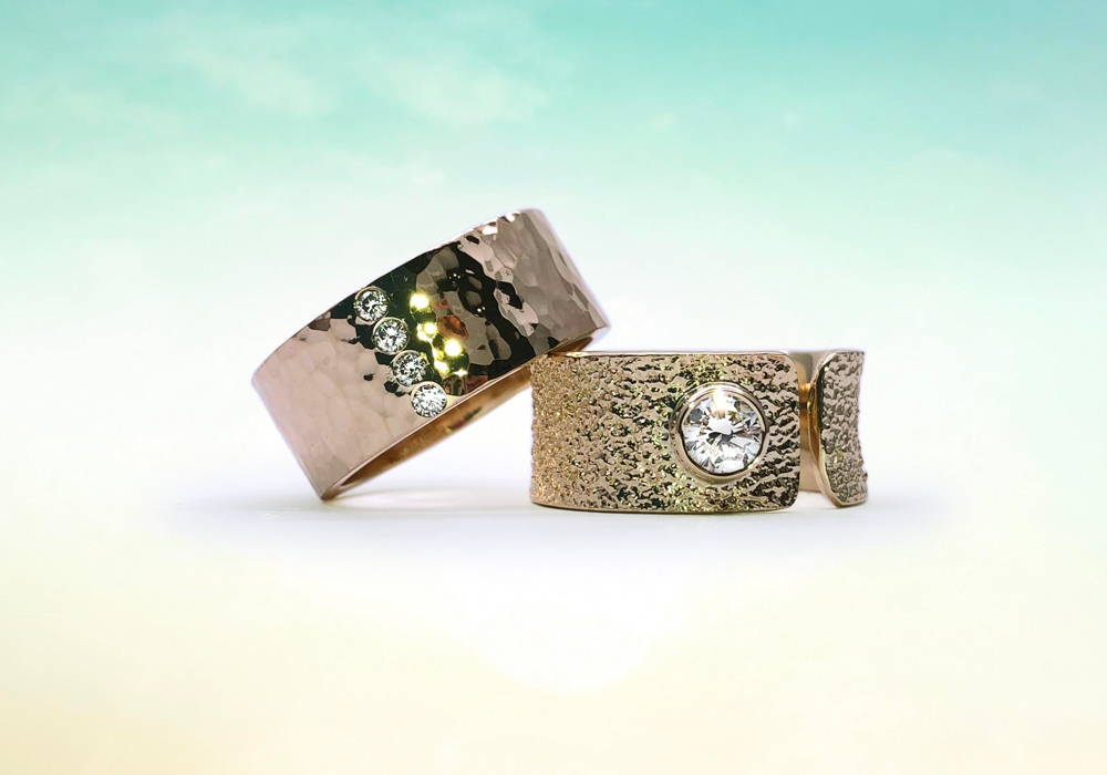 Duo of large textured yellow gold rings with 4 small diamonds and one large diamond