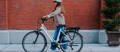 Woman walking with Gazelle electric bike