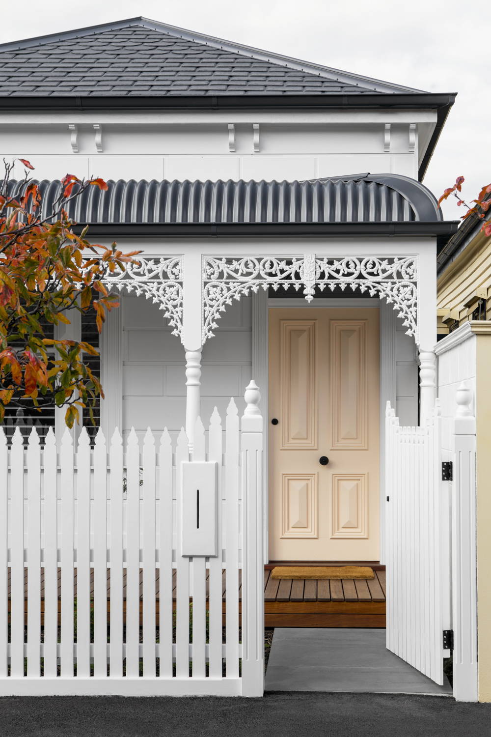 Outside facade of cottage-style home with peach front door