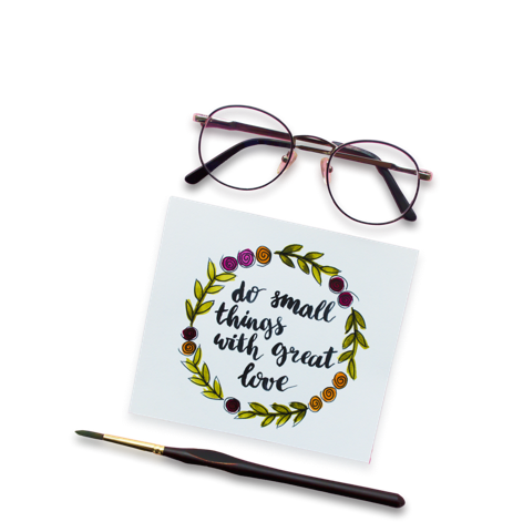 Glasses, paintbrush, and handwritten letter that says "Do small things with great love"