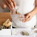 A person refills a glass spice jar from Gneiss spice with small brown spice seeds