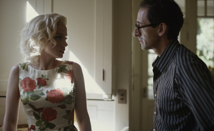 Marilyn talking to another character with a worried look on her face inside a home.