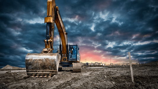 A construction digger against a dramatic sky