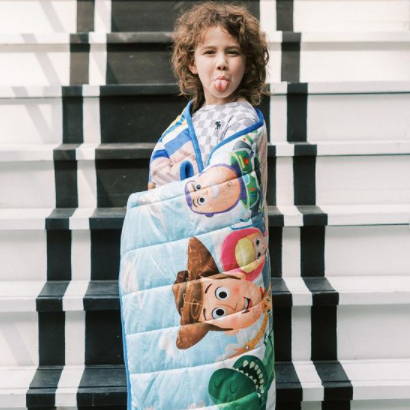 Kid wrapped in Toy Story blanket
