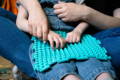 Mother helping her autistic child in tactile learning on a silicone board.