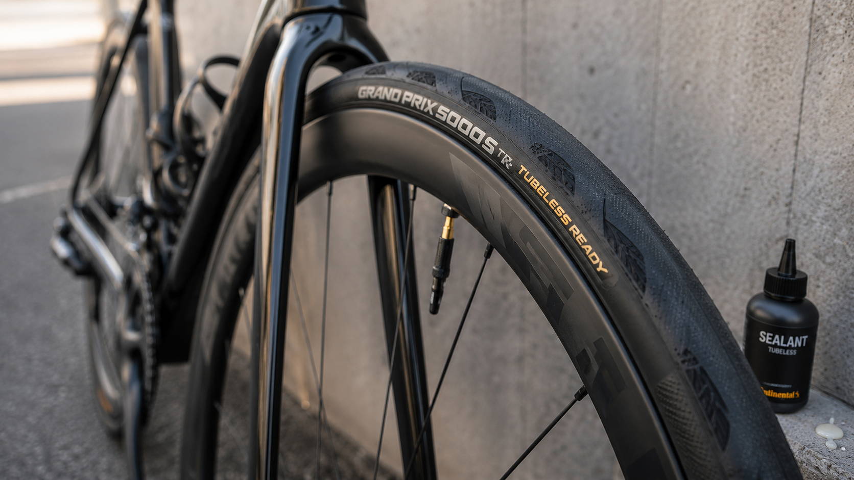 Tubeless-ready racefietsband met zichtbaar ventiel en sealant voor lekbescherming onderweg