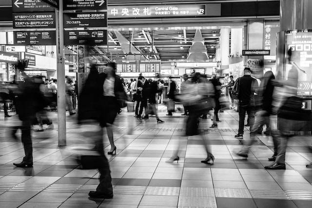persone in una stazione ferroviaria fotografate con la tecnica della lunga esposizione. effetto mosso