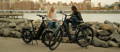 Two women sitting next to electric bikes in NYC park