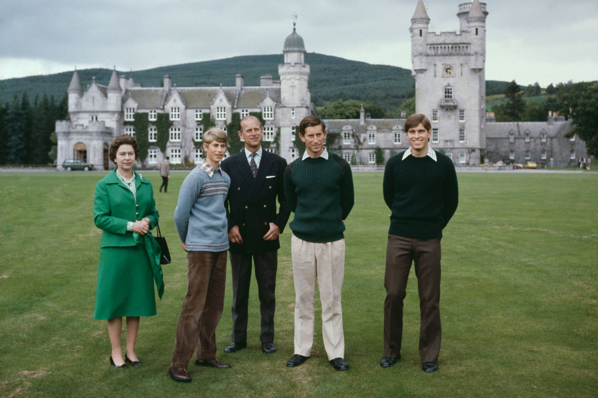 A 1979 photograph of members of the British royal family posing in front of Balmoral Castle. It is a cloudy day. From left: Queen Elizabeth II in a green dress, a young Prince Edward in a shirt and trousers, Prince Philip in a suit, a young King Charles I