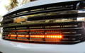 2023 white chevy suburban with two led light bars behind the grille for off roading