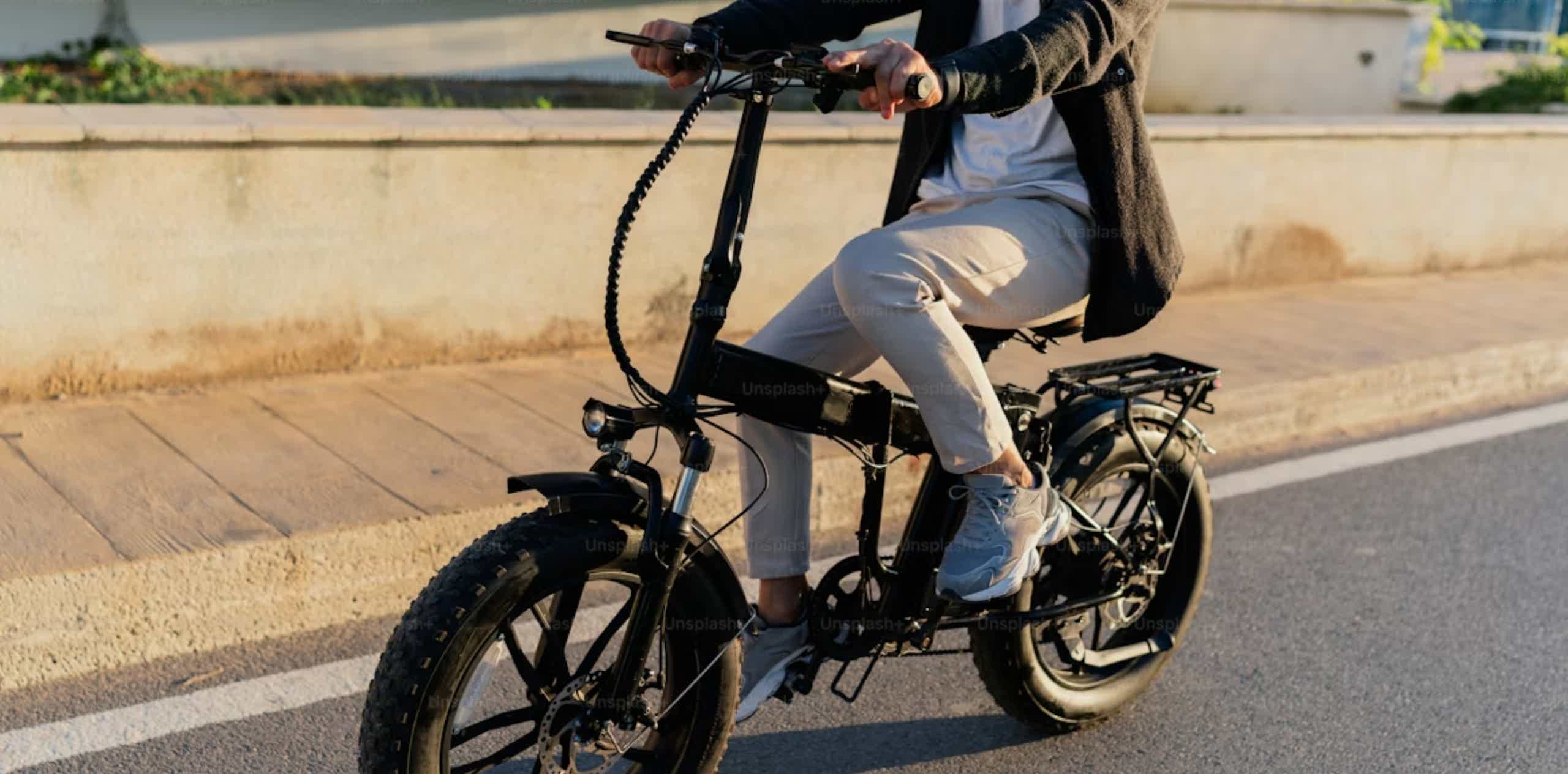 Imagen de recurso de una persona manejando una bicicleta eléctrica plegable.