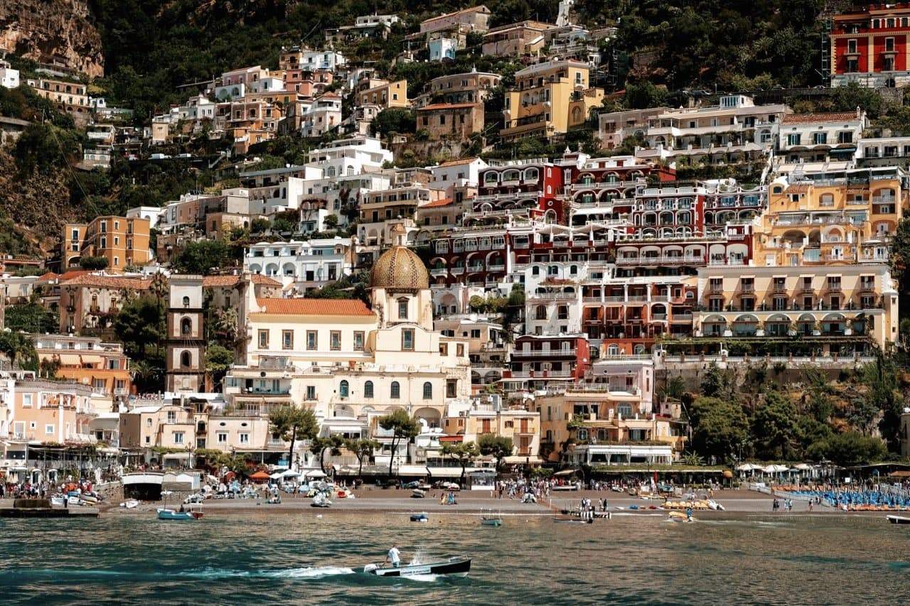 A photograph of the Positano landscape in earthy oranges, creams and greens