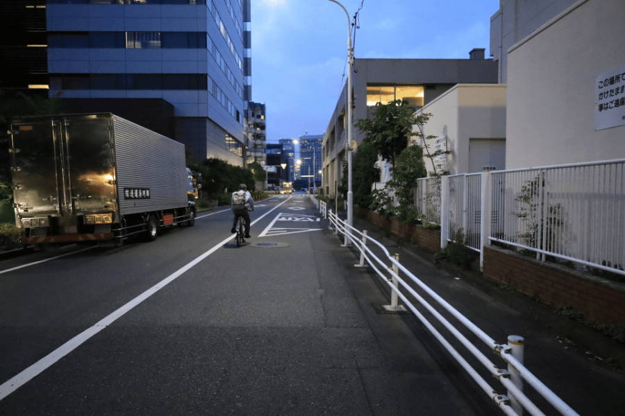 夕暮れ時に自転車で帰る人の後ろ姿