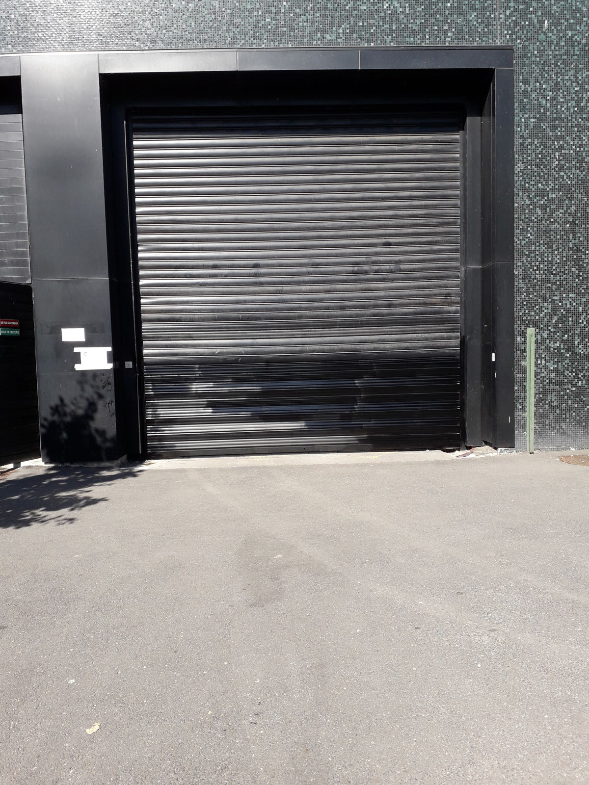Porte rapide à enroulement installée sur la façade d'un bâtiment d'activité