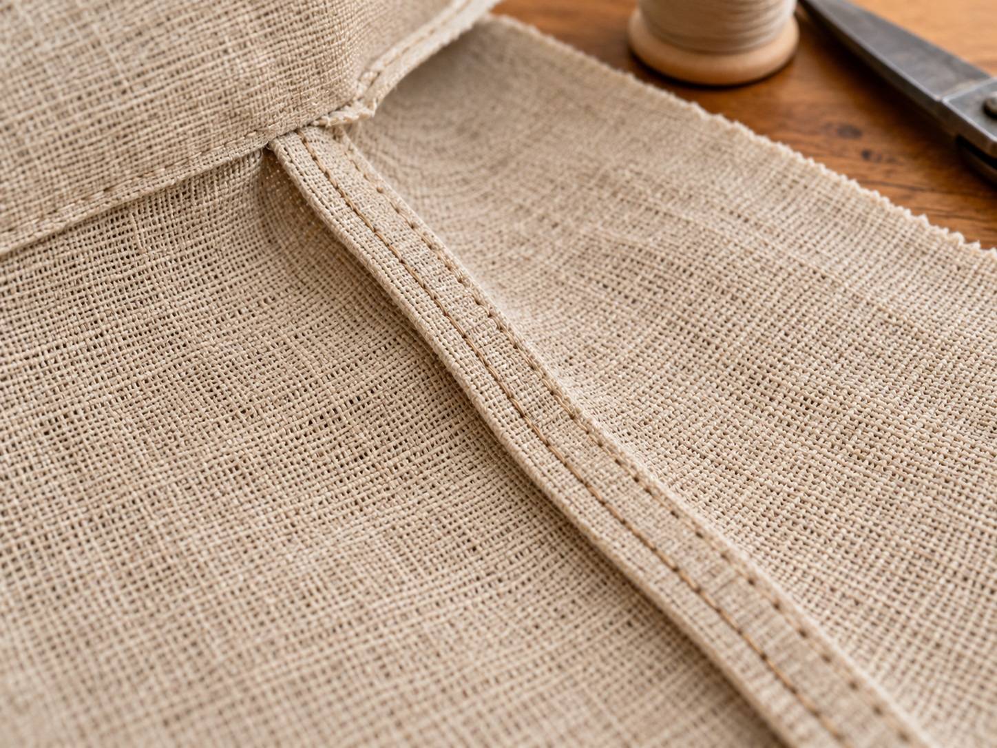 Finished French seam enclosing raw edges on lightweight woven hemp fabric