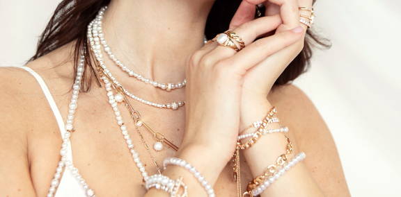 A model in an assortment of ettika pearl jewelry