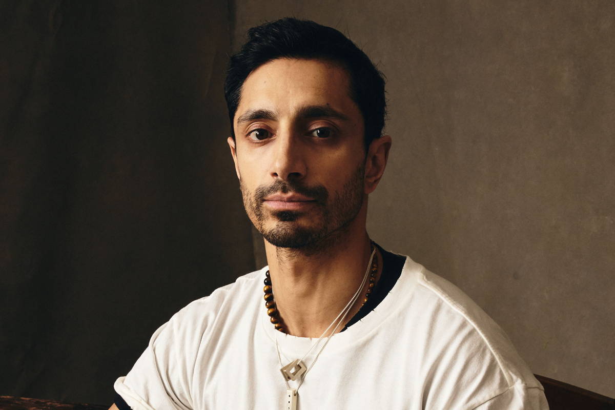 Image may contain: Riz Ahmed, Clothing, Sleeve, Person, Sitting, Adult, Face, Head, Black Hair, Hair, and Photography