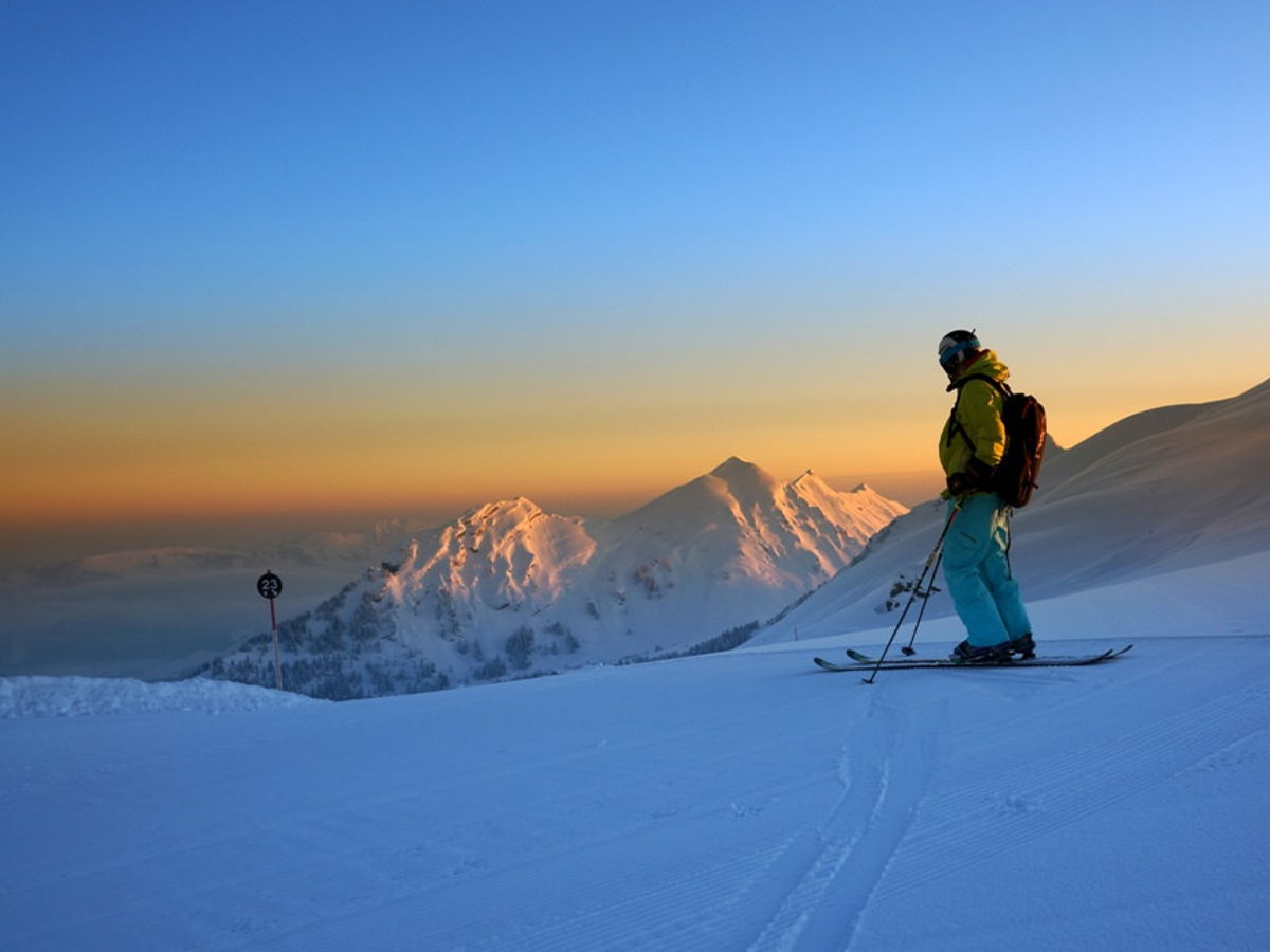 Skifahrer auf Piste bei Sonnenuntergang