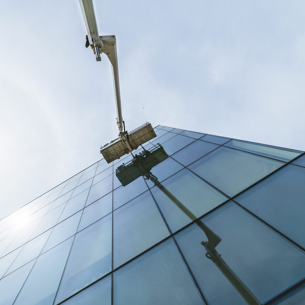Commercial window cleaning with MEWP on side of a tall building