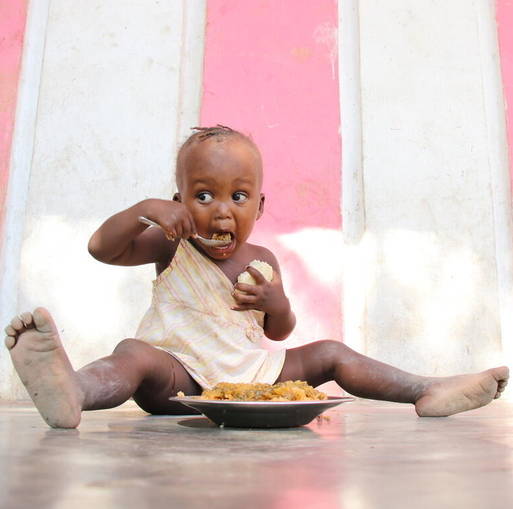 Toddler eating bowl of food