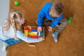 Children playing with colorful Montessori tangram blocks.